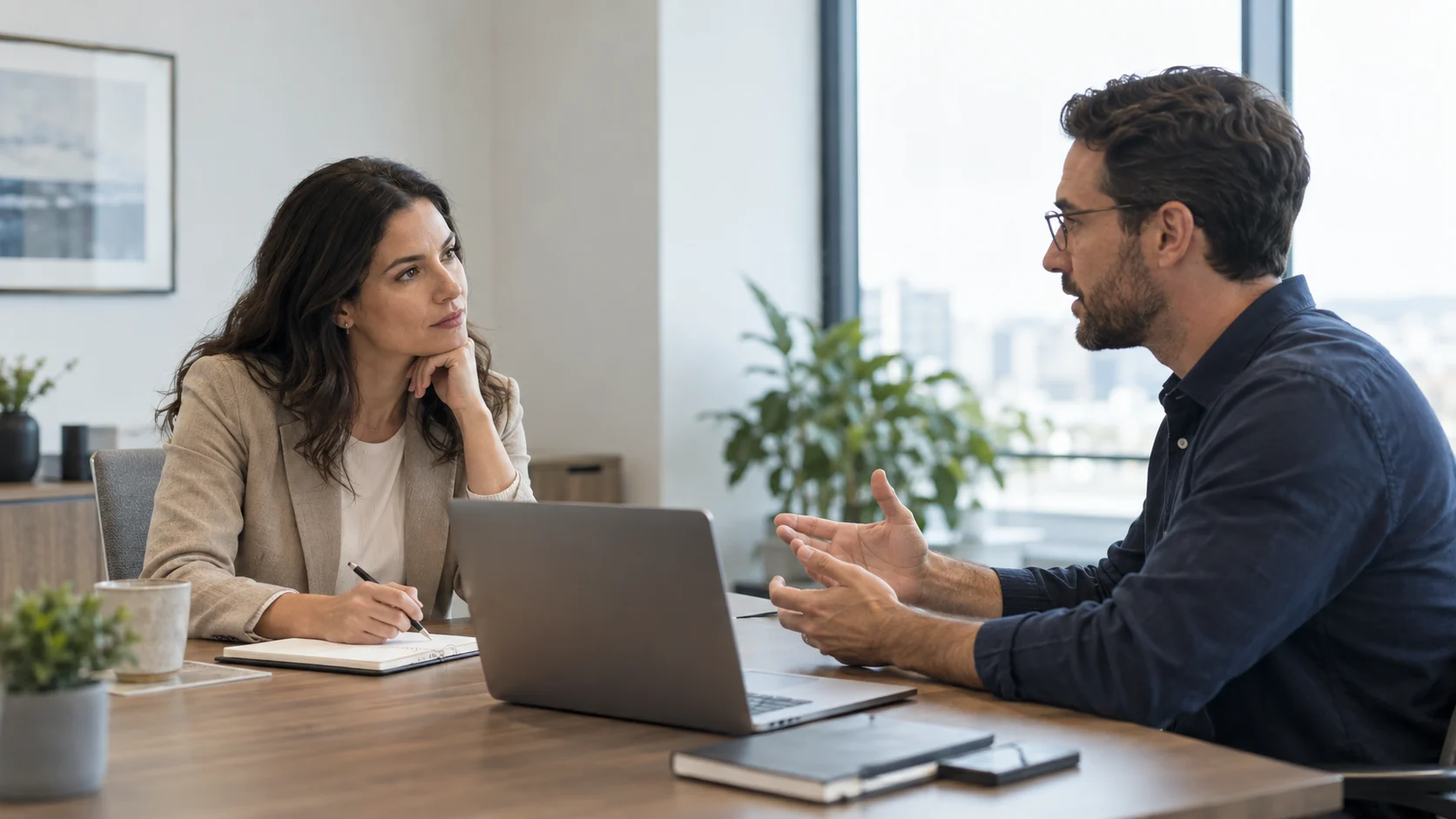 wo professionals calmly discussing a workplace concern across an office table.